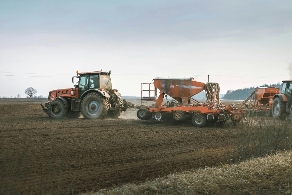 Tractors working in a rural field using advanced machinery for sowing and Strip-Till techniques.